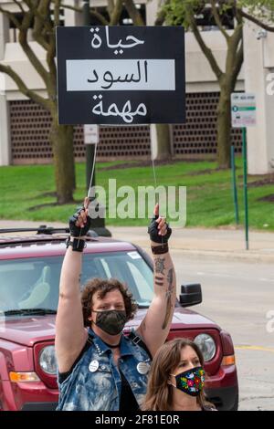 Detroit, Michigan, USA. April 2021. Aktivisten sammeln sich vor dem Polizeihauptquartier in Detroit und protestieren gegen die Polizei, die Hauswirten illegal geholfen hat, Mieter zu vertreiben. Die Kundgebung wurde von Detroit will Breathe und Detroit Eviction Defense organisiert. Das Zeichen, in arabischer Sprache, liest Black Lives Matter. Kredit: Jim West/Alamy Live Nachrichten Stockfoto
