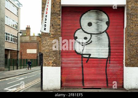 Stiks Werk (britischer Graffiti-Künstler mit Sitz in London). Große Stabfiguren auf lackierten Fensterläden. East London, Großbritannien. April 2013 Stockfoto