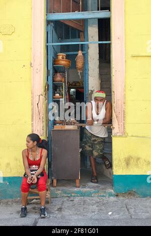 Kubanischer Ladenbesitzer und Verkaufsassistent im Geschäft, in dem Souvenirs in Havanna Vieja verkauft werden Stockfoto