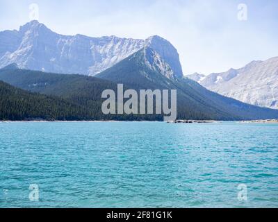 Türkisfarbener See an einem sonnigen Tag mit einem großen Berg Im Hintergrund Stockfoto