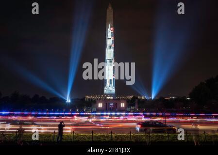 Vor dem Washington Monument rasten Polizeilichter über die 15th Street, während die „Go for the Moon“, die Saturn V Rakete, angezeigt wird. Stockfoto