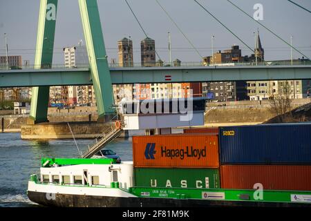 KÖLN, DEUTSCHLAND - 05. Apr 2021: Binnenschiff mit Containern auf dem Rhein in Köln bei Severinsbrücke, Severin-Brücke Stockfoto