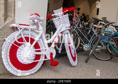 München, Deutschland. April 2021. In der Fußgängerzone im Stadtzentrum steht ein Fahrrad, das aus weißer und roter Wolle gestrickt und gehäkelt wurde. Die weißrussische Gemeinde Razam e.V. möchte mit dieser Aktion auf die Situation der belarussischen Flüchtlinge in der Ukraine aufmerksam machen. Kredit: Peter Kneffel/dpa/Alamy Live Nachrichten Stockfoto