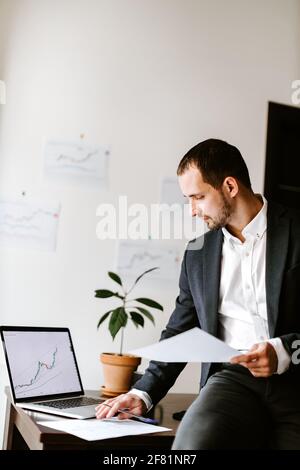Finanzmanager analysiert Preisdaten Trenddiagramm auf Laptop in Büro Stockfoto
