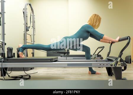Junge Frau macht Pilates auf dem Simulator Stockfoto