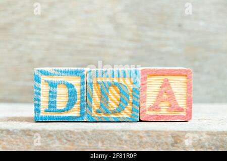 Farbiger Buchstabenblock in Wort DDA (Abkürzung für Abschreibung, Erschöpfung und Abschreibung oder Nachfragekonto) auf Holzhintergrund Stockfoto