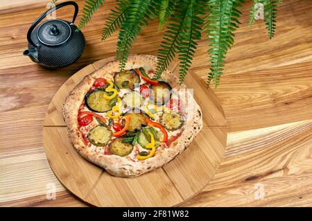 Pizza Capri steht auf einem Holzständer Stockfoto