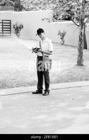 JOHANNESBURG, SÜDAFRIKA - 13. Mär 2021: Johannesburg, Südafrika - 11. September 2010: Post Mailman Hand liefert Post in einem wohlhabenden Vorort Stockfoto