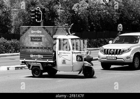 JOHANNESBURG, SÜDAFRIKA - 13. März 2021: Johannesburg, Südafrika - 19. Oktober 2014: Small TukTuk Lebensmittelgeschäft Home Delivery Fahrzeuge fahren Th Stockfoto