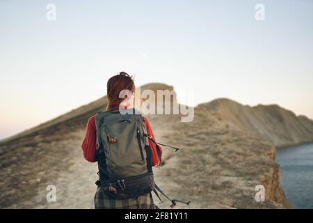 Die Touristenfrau steigt an der Spitze der Bar entlang Die Straße mit einem Rucksack auf dem Rücken Stockfoto