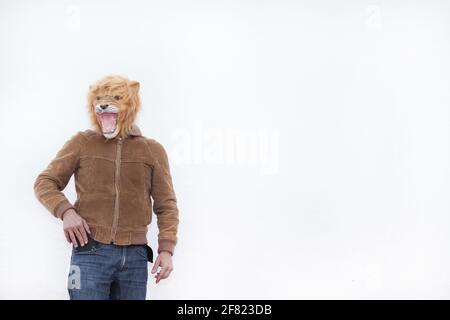 Ein Mann mit einem brüllenden Löwen voller Maske posiert für Kamera auf weißem Hintergrund isoliert Stockfoto