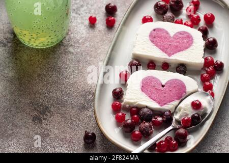 Köstliches Eis mit Beerenherzfüllung Stockfoto
