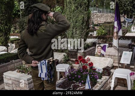 Jerusalem, Israel. April 2021. IDF-Soldaten legen kleine israelische Fahnen mit schwarzen Bändern auf jedes der Gräber und grüßen die Gefallenen auf dem Militärfriedhof von Mount Herzl vor dem Gedenktag, Jom Hazikaron, für die gefallenen Soldaten und Opfer von Terroranschlägen. Der Gedenktag wird am 14. April 2021 markiert. Kredit: Nir Alon/Alamy Live Nachrichten Stockfoto