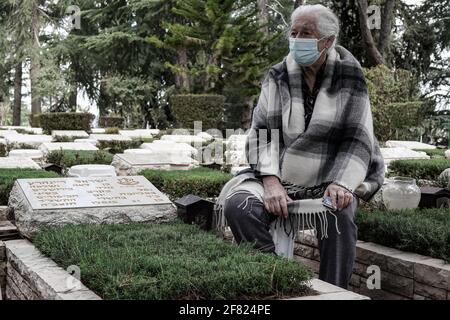 Jerusalem, Israel. April 2021. IDF-Soldaten legen kleine israelische Fahnen mit schwarzen Bändern auf jedes der Gräber und grüßen die Gefallenen auf dem Militärfriedhof von Mount Herzl vor dem Gedenktag, Jom Hazikaron, für die gefallenen Soldaten und Opfer von Terroranschlägen. Der Gedenktag wird am 14. April 2021 markiert. Kredit: Nir Alon/Alamy Live Nachrichten Stockfoto