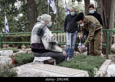 Jerusalem, Israel. April 2021. IDF-Soldaten legen kleine israelische Fahnen mit schwarzen Bändern auf jedes der Gräber und grüßen die Gefallenen auf dem Militärfriedhof von Mount Herzl vor dem Gedenktag, Jom Hazikaron, für die gefallenen Soldaten und Opfer von Terroranschlägen. Der Gedenktag wird am 14. April 2021 markiert. Kredit: Nir Alon/Alamy Live Nachrichten Stockfoto