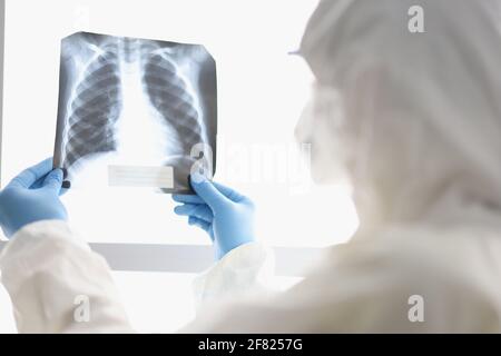 Der Arzt in Schutzanzug untersucht die Nahaufnahme der Röntgenstrahlung Stockfoto