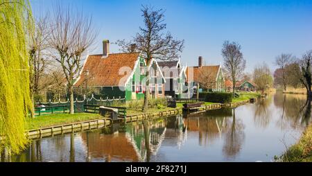 Traditionelle holländische Holzhäuser spiegeln sich im Kanal in Zaanse Schans, Niederlande, wider Stockfoto