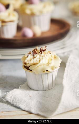 Eine vertikale Aufnahme eines kleinen Cupcake mit weißer Creme Auf einem Tisch Stockfoto