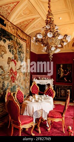 Der Innenraum der Villa Monastero. Comer See, Italien. Das Innere der königlichen Burg im roten Stil. Antike Möbel, Gemälde und reiche Möbel. Stockfoto