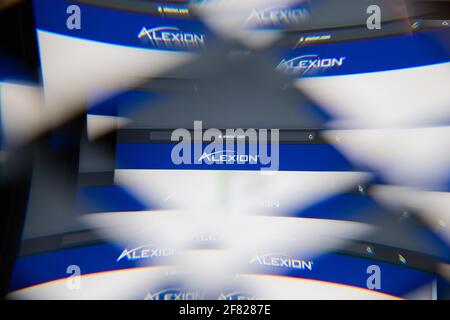 Mailand, Italien - 10. APRIL 2021: Alexion Pharmaceuticals-Logo auf dem Laptop-Bildschirm durch ein optisches Prisma gesehen, kreative Interpretation. Dynamisch und einzigartig Stockfoto
