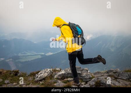 Seien Sie vorsichtig, wenn Sie in den Bergen wandern. Frau, die nach dem Ausrutschen auf nasse Felsen herunterfällt. Reiseversicherung gegen Körperverletzung Konzept Stockfoto