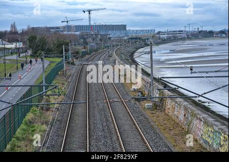 Dublin, Irland - 14. März 2021: Wunderschöne, am Abend kontrastierende, nach Norden ausgerichtete Ansicht der irischen Eisenbahn entlang der Küste von Dublin, gesehen bei Blackrock Stockfoto