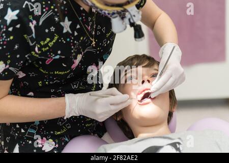 Zahnarzt, der die Zähne des Jungen in der Klinik untersucht Stockfoto