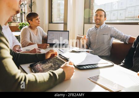Mann, der in einem Geschäftstreffen Vorschläge macht. Männlicher Vorstandssprach in Teambesprechung. Stockfoto