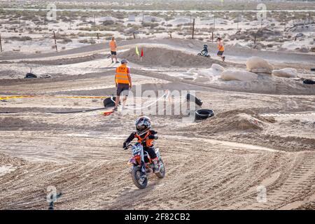 DUBAI, VEREINIGTE ARABISCHE EMIRATE - Mar 20, 2021: junior Motocross-Fahrer und Motorrad auf der Strecke in der Wüste und Schutzausrüstung Stockfoto