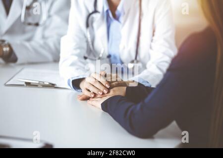 Unbekannte Frau-Arzt beruhigende weibliche Patientin, Nahaufnahme. Empathie imedicine während Coronavirus Pandemie. Covid 2019 Stockfoto