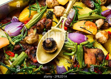 Gebackenes Fleisch mit Kartoffeln, Äpfeln, Pilzen und Okra. Gebratenes Fleisch mit Gemüse. Stockfoto