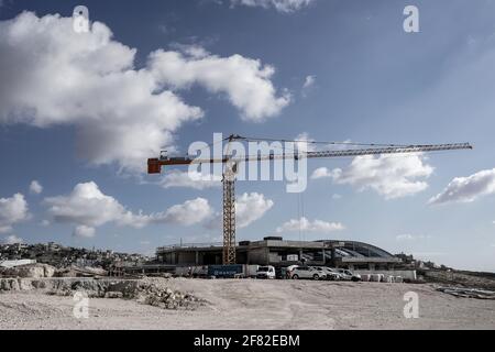 Jerusalem, Israel. April 2021. Der Bau in Homat Shmuel, oder Har Homa, in Ostjerusalem, mit dem palästinensischen Dorf Umm Tuba im linken Hintergrund, auf 1991 enteigneten Land, als ein Jerusalemer Komitee einen Plan für weitere 540 Wohneinheiten billigt. Das jüdische Viertel jenseits der Grünen Linie, die Abgrenzungslinie des Waffenstillstands vor dem Sechstagekrieg von 1967, der Israel und das Westjordanland trennt, wird von einem Großteil der Welt als illegale israelische Siedlung angesehen. Der Plan ist das erste große Bauprojekt über die Grenzen vor 1967 seit US-Präsident B Stockfoto