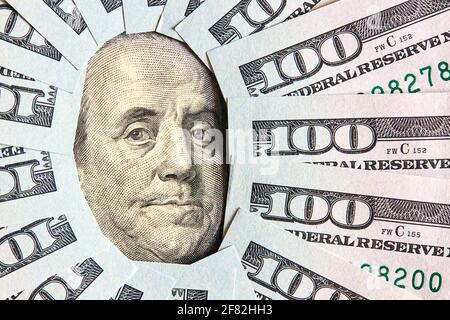 Viele gefaltete 100 USD-Scheine layed Wie Vintage-Sonnengesicht strahlt um Benjamin Franklin Porträt aus 100 Dollar US-amerikanische Rechnung Stockfoto