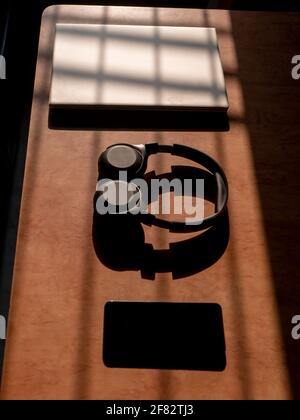 Büro zu Hause mit IT-Ausrüstung und Online-Kommunikation. Arbeiten von zu Hause aus und Fernzugriffskonzept. Selektiver Fokus und Sonnenlicht auf IT-Ausrüstung Stockfoto