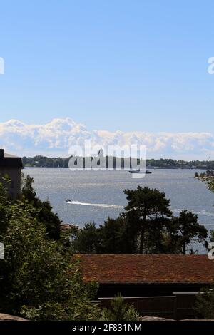 Ein Blick von der Zooinsel Korkeasaari in die Innenstadt von Helsinki, Juni 2019. Sonniger Sommertag. Sie können Wälder, Boote und Gebäude der Hauptstadt sehen. Stockfoto