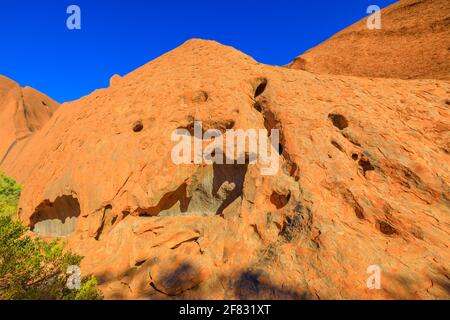 Details von roten Sandsteinfelsen mit Höhlen entlang des Mala Walk am Fuße des Ayers Rock im Uluru-Kata Tjuta National Park, Northern Territory, Australien. Rot Stockfoto