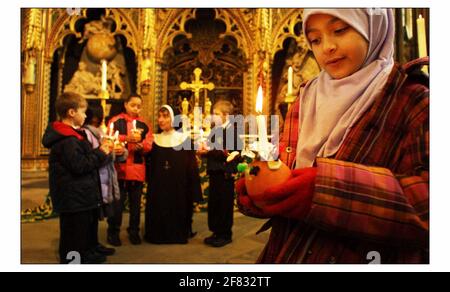 Kinder von der St Barnabas Church of England Schule, Pimlico, machen sich bereit, an den jährlichen Christingle Feiern der Childrens Societys in Westminster Abbey teilzunehmen. Dieses Jahr Thema ist ein Licht auf BullyingThe Orange symbolisiert die Welt, das rote Band das Blut Christi und die Kerze das Licht der Welt. PIC David Sandison 28/11/2002 Stockfoto