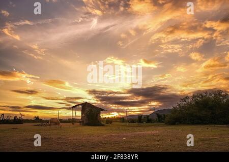 Kleine sooden Hütte auf Wüstenwiese am Nachmittag Sonnenuntergang Himmel Stockfoto