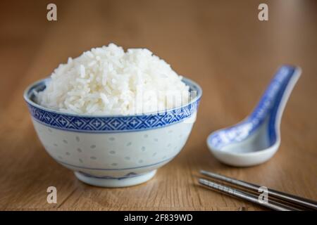 Eine Schüssel mit weißem Reis auf Holzgrund Stockfoto