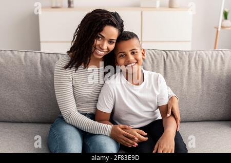 Portrait von schwarzer Mutter und Sohn umarmt Stockfoto