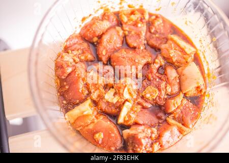 In einer Glasschüssel mariniertes Schweinefleisch mit Karamell und Gewürzen Stockfoto