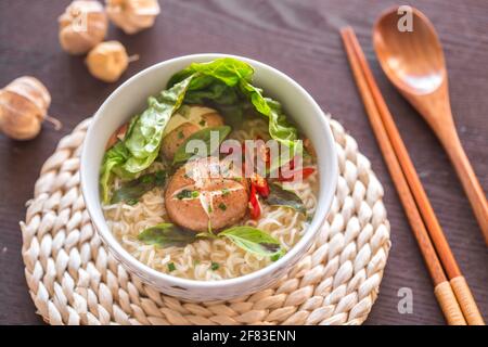 Essstäbchen nehmen Nudeln aus einer Schüssel mit vegetarischen Nudeln Stockfoto