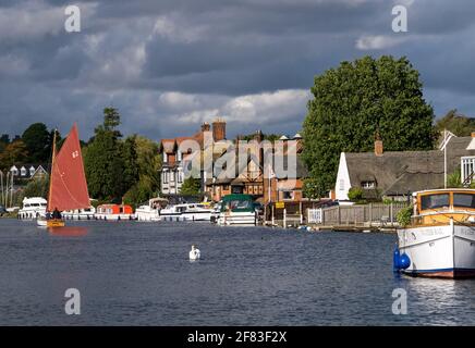 Segeln auf dem Fluss Bure, Teil der Norfolk Broad, im malerischen Horning, mit ihm Riverside Buildings, Horning, Norfolk, England, Großbritannien Stockfoto