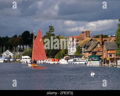 Segeln auf dem Fluss Bure, Teil der Norfolk Broad, im malerischen Horning, mit ihm Riverside Buildings, Horning, Norfolk, England, Großbritannien Stockfoto