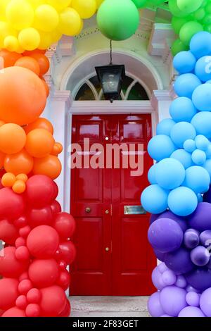 Da die Sperrbeschränkungen am 12. Mai 2021 enden, schmückt ein lokales Unternehmen seine Eingangstür mit farbenfrohen Baloons, um Kunden willkommen zu heißen. Stockfoto