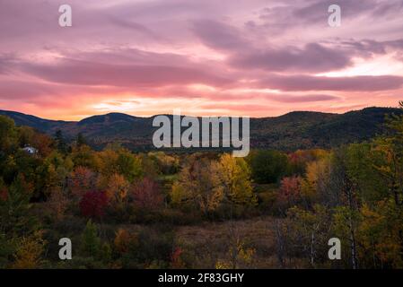 Dramatischer Herbstuntergang über einem hölzernen Gebirge auf dem Gipfel Von Herbstlaub Stockfoto