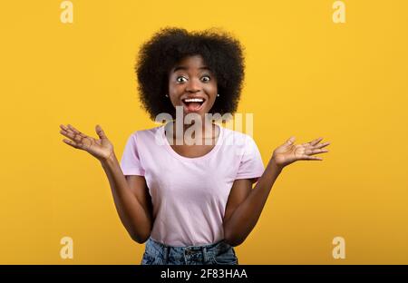 Omm. Überglücklich afroamerikanische Dame, die vor Aufregung schrie und die Kamera ansah, posierte über gelbem Studiohintergrund Stockfoto