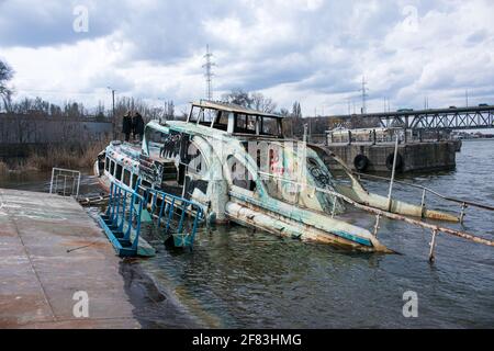 Altes rostig versunkenes Schiff im Wasser auf dem Territorium des Flusshafens. Altes versunkenes Boot auf dem Fluss. Stockfoto