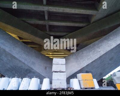 Der hohe Winkelpunkt der Vire der Betonbrücke mit Industrielle Lagerung in der Nähe der Baustelle im Sommer Stockfoto