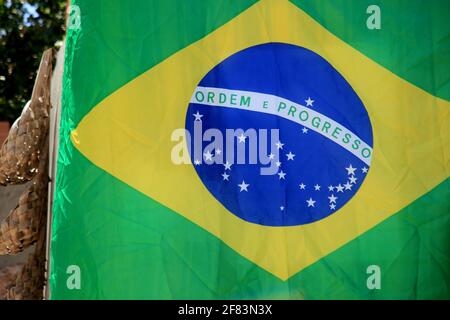 salvador, bahia, brasilien - 21. januar 2021: Die Flagge brasiliens ist neben einer Hütte im Viertel Itapua in der Stadt Salvador zu sehen. *** Lokale Capti Stockfoto